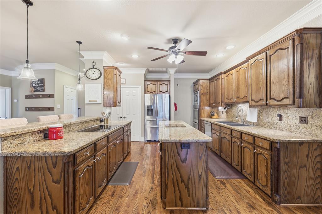 4800 Shiloh Road Double Oak, TX 75022 - Photo 13 of 40 a kitchen with kitchen island granite countertop lots of stainless steel appliances a stove a sink dishwasher and cabinets with wooden floor