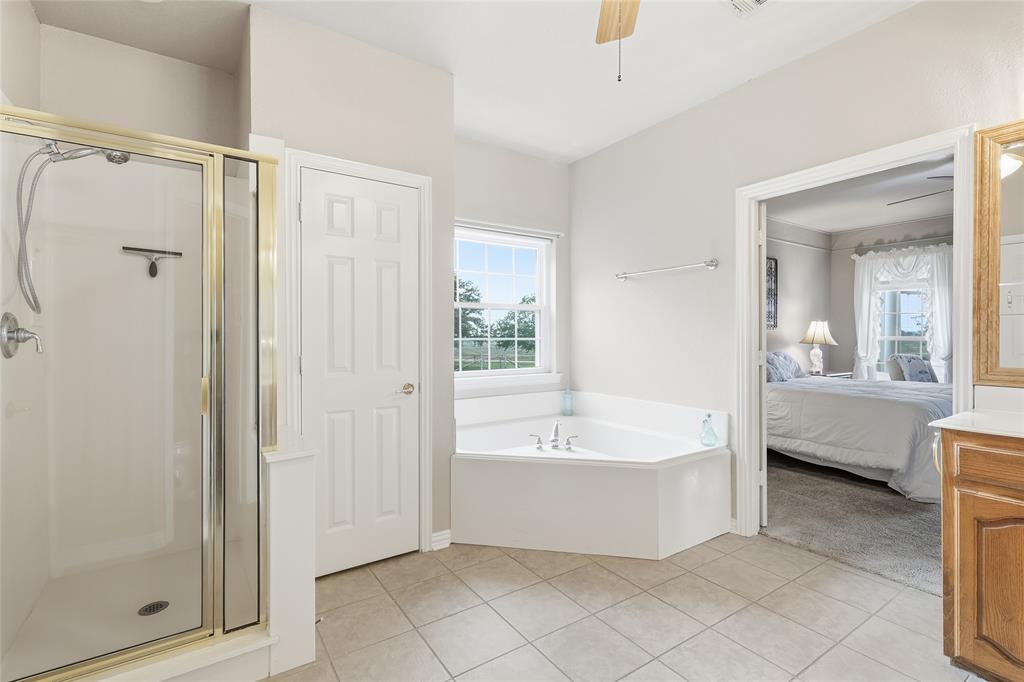 4800 Shiloh Road Double Oak, TX 75022 - Photo 20 of 40 a bathroom with a bathtub a mirror a shower and vanity