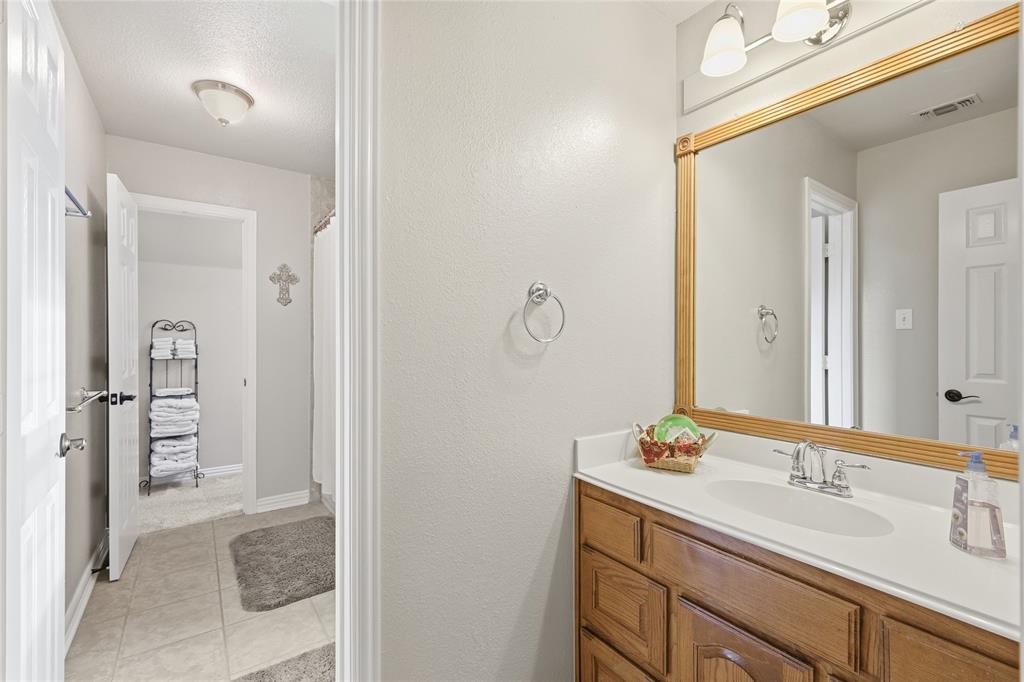 4800 Shiloh Road Double Oak, TX 75022 - Photo 25 of 40 a bathroom with a sink vanity granite and a mirror