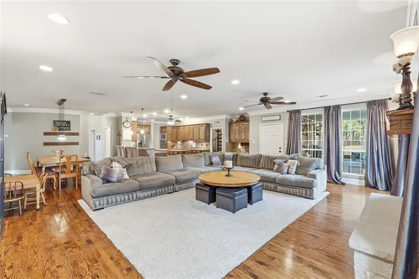 a kitchen with kitchen island granite countertop lots of stainless steel appliances a stove a sink dishwasher and cabinets with wooden floor