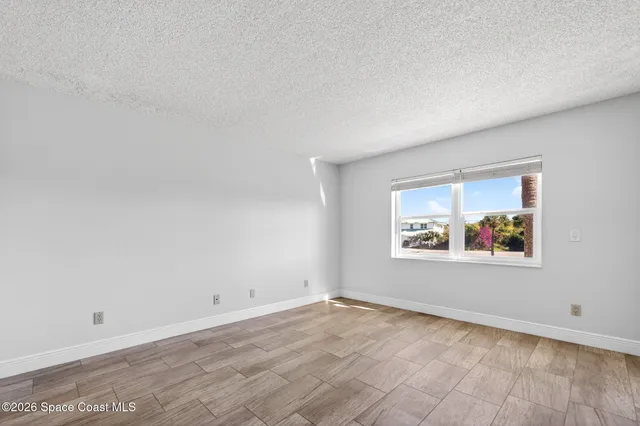 an empty room with a painting on the wall and a window