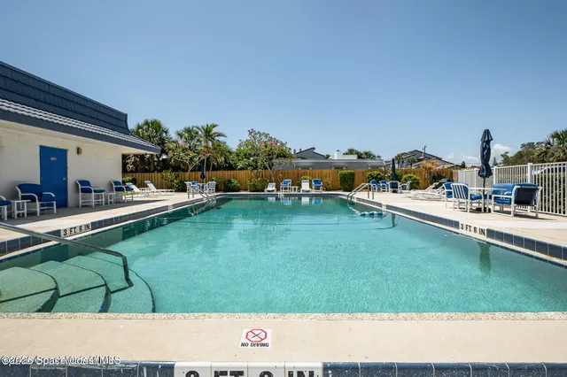 a view of a tennis ground with large trees