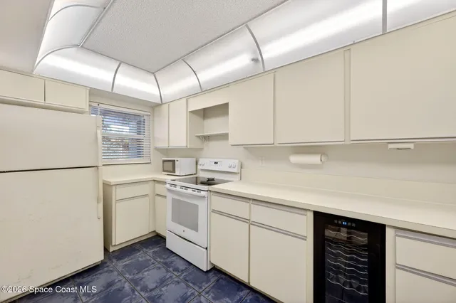 a kitchen with a sink a refrigerator and cabinets