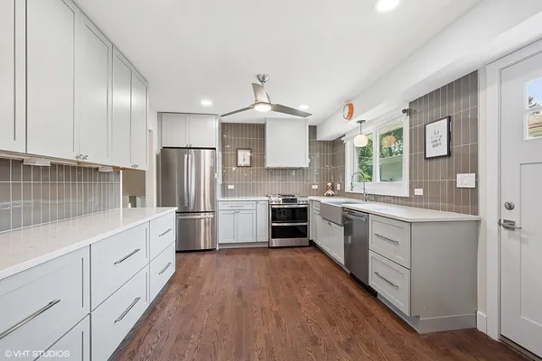 a kitchen with white cabinets stainless steel appliances and sink