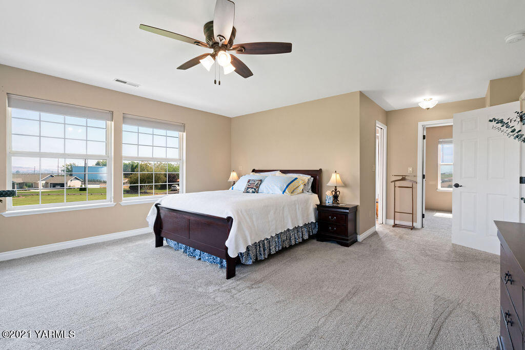 13050 West Barrett Road Yakima, WA 98908 - Photo 23 of 55 a spacious bedroom with a large bed and a chandelier