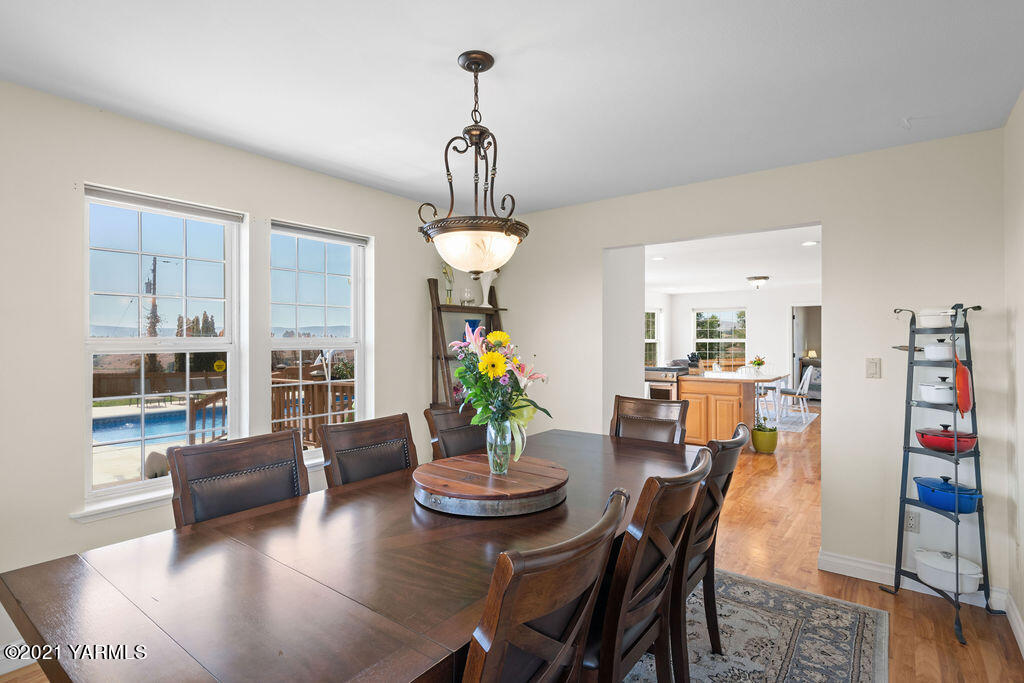 13050 West Barrett Road Yakima, WA 98908 - Photo 9 of 55 a view of a dining room with furniture wooden floor and chandelier