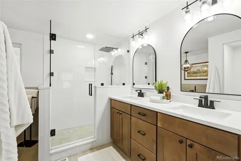 a bathroom with a double vanity sink mirror and shower