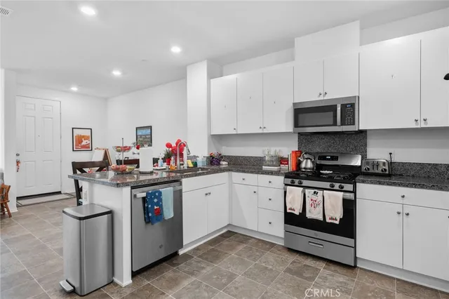 a kitchen with stainless steel appliances granite countertop a stove sink and cabinets
