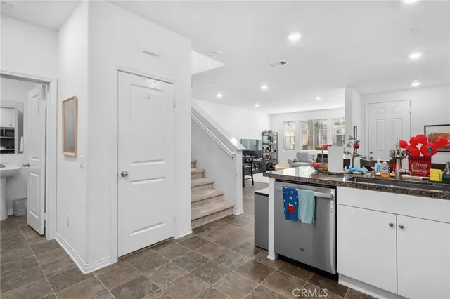 a kitchen with white cabinets and sink