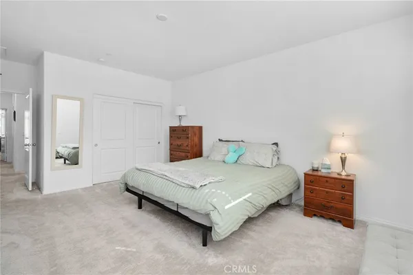 a spacious bedroom with a bed and a lamp