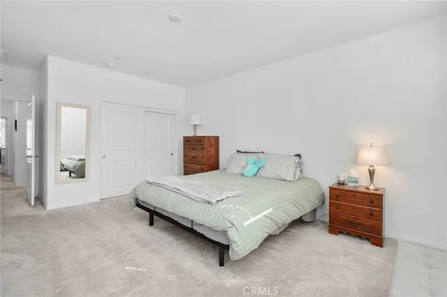 a spacious bedroom with a bed and a lamp