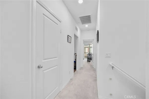 a view of a hallway with a white walls and stairs