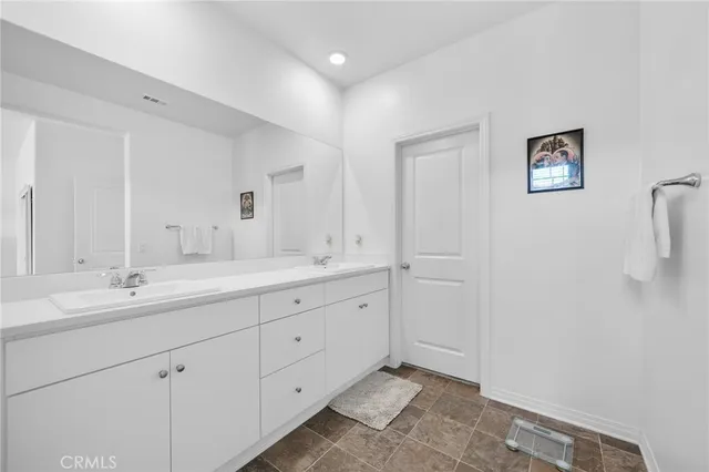 a spacious bathroom with a double vanity sink and a mirror