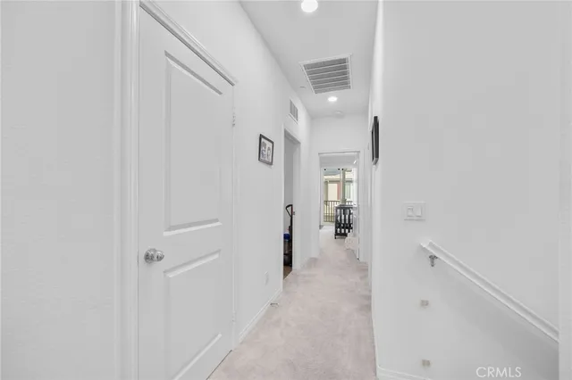 a view of a hallway with a white walls and stairs