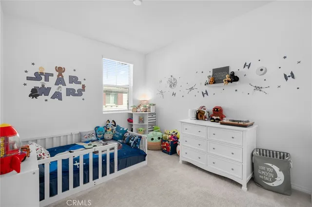 a room with baby crib and wooden floor