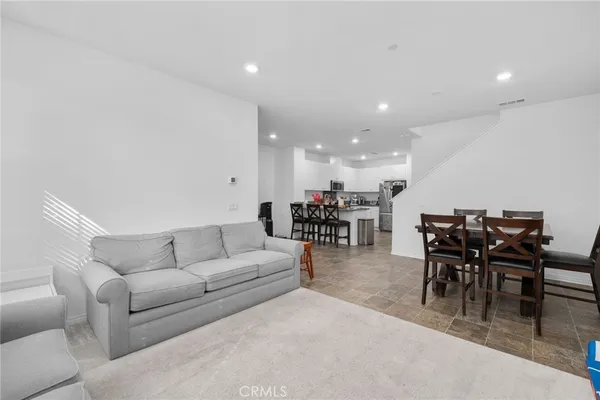 a living room with furniture and a dining table with kitchen view
