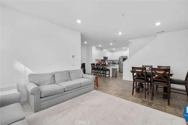 a living room with furniture and a dining table with kitchen view