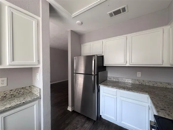 a kitchen with a refrigerator sink and cabinets