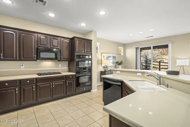 a large kitchen with stainless steel appliances granite countertop a sink and cabinets
