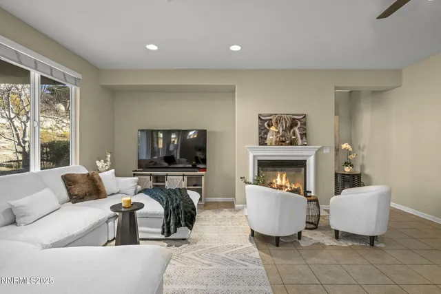 a living room with furniture a flat screen tv and a fireplace