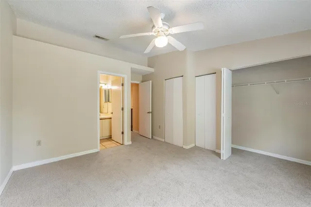an empty room with a ceiling fan and a window
