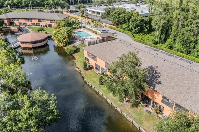 an aerial view of a house with a garden and lake view