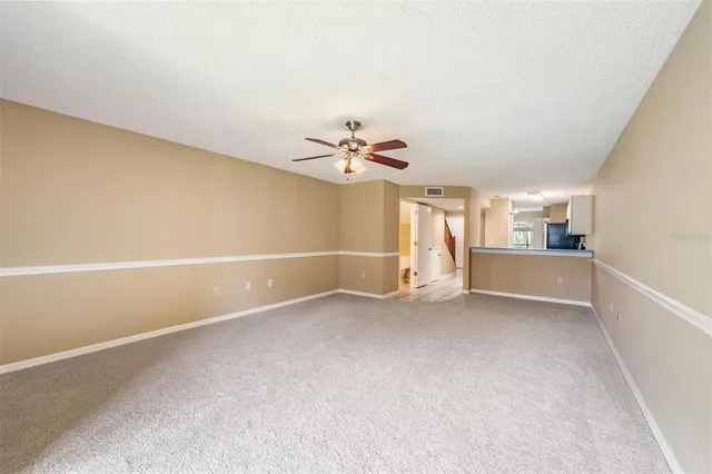 a view of a livingroom with a ceiling fan and window