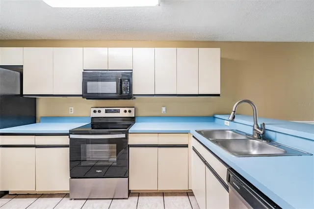 a kitchen with stainless steel appliances granite countertop a sink stove and microwave