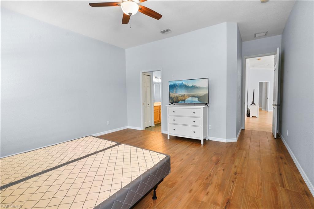 6522 Waverly Green Way Naples, FL 34110 - Photo 11 of 30 a bedroom with a bed and wooden floor