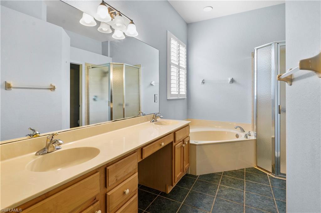 6522 Waverly Green Way Naples, FL 34110 - Photo 12 of 30 a bathroom with a tub sink and a mirror