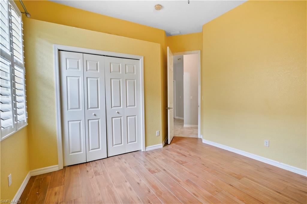 6522 Waverly Green Way Naples, FL 34110 - Photo 17 of 30 an empty room with wooden floor and closet area