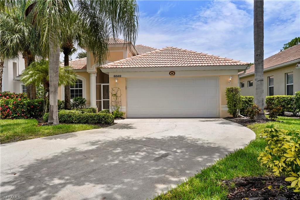 6522 Waverly Green Way Naples, FL 34110 - Photo 2 of 30 a front view of a house with a garden