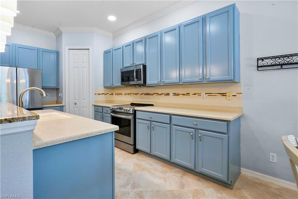6522 Waverly Green Way Naples, FL 34110 - Photo 6 of 30 a kitchen with a stove a sink and a refrigerator