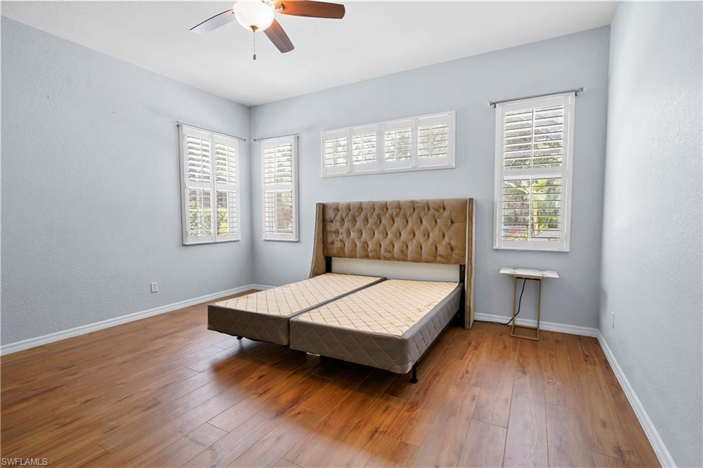 6522 Waverly Green Way Naples, FL 34110 - Photo 10 of 30 a bedroom with a bed and a chandelier