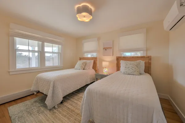 a bedroom with two beds and a large window