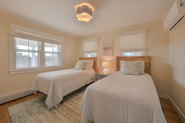 a bedroom with two beds and a large window