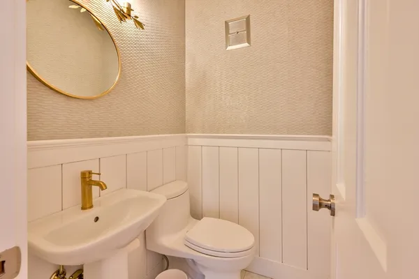 a bathroom with a toilet a sink and mirror