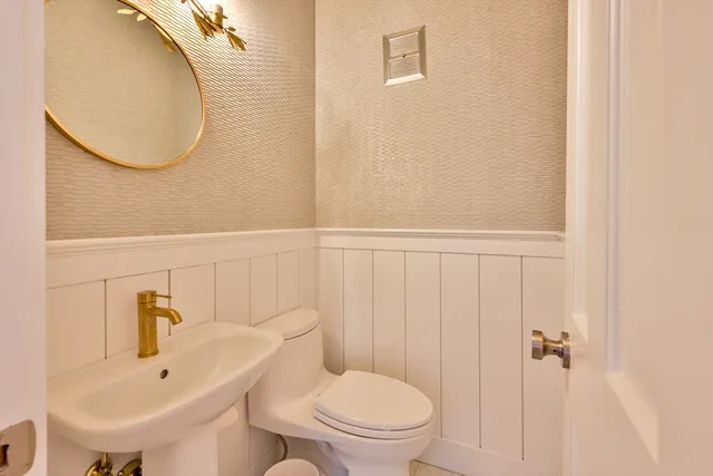 a bathroom with a toilet a sink and mirror