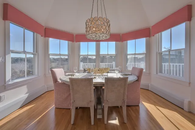 a dining room with furniture a chandelier and wooden floor