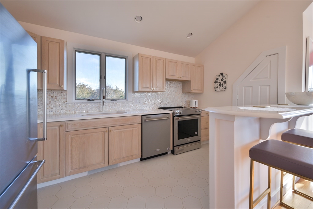 63 Monomoy Road Nantucket, MA 02554 - Photo 28 of 35 a kitchen with stainless steel appliances granite countertop a stove a sink and a refrigerator