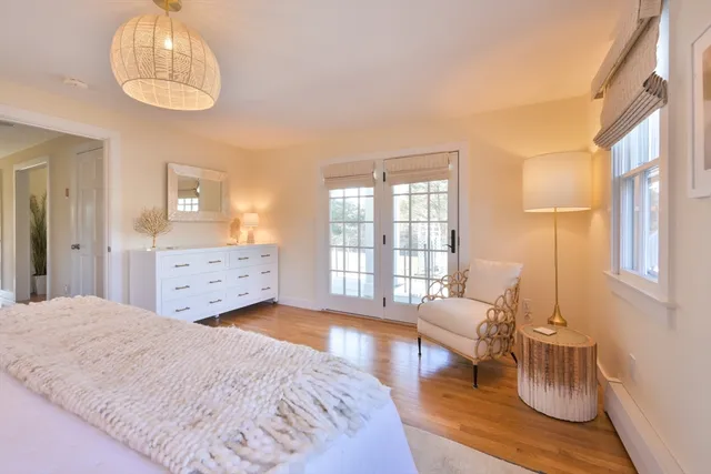 a spacious bedroom with a bed and wooden floor