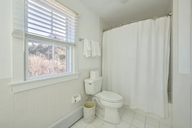 a white toilet sitting next to a window