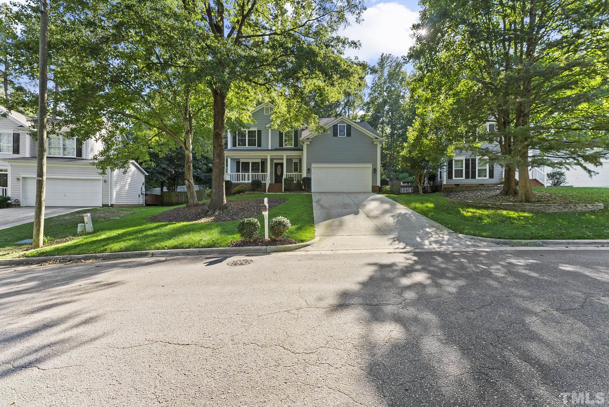 a front view of a house with a yard and trees