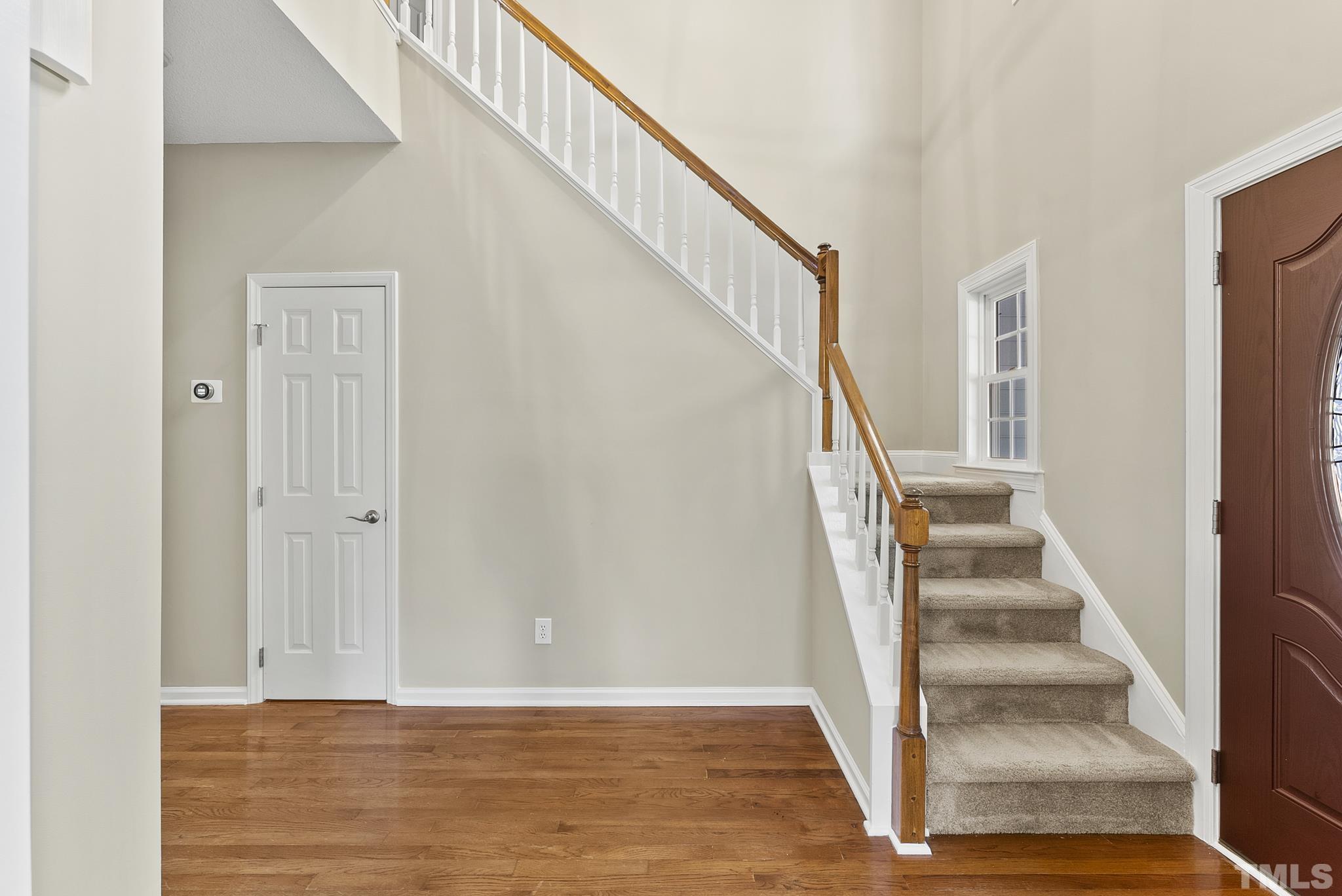 313 Catlin Road Cary, NC 27519 - Photo 3 of 27 a view of staircase with wooden floor and white walls