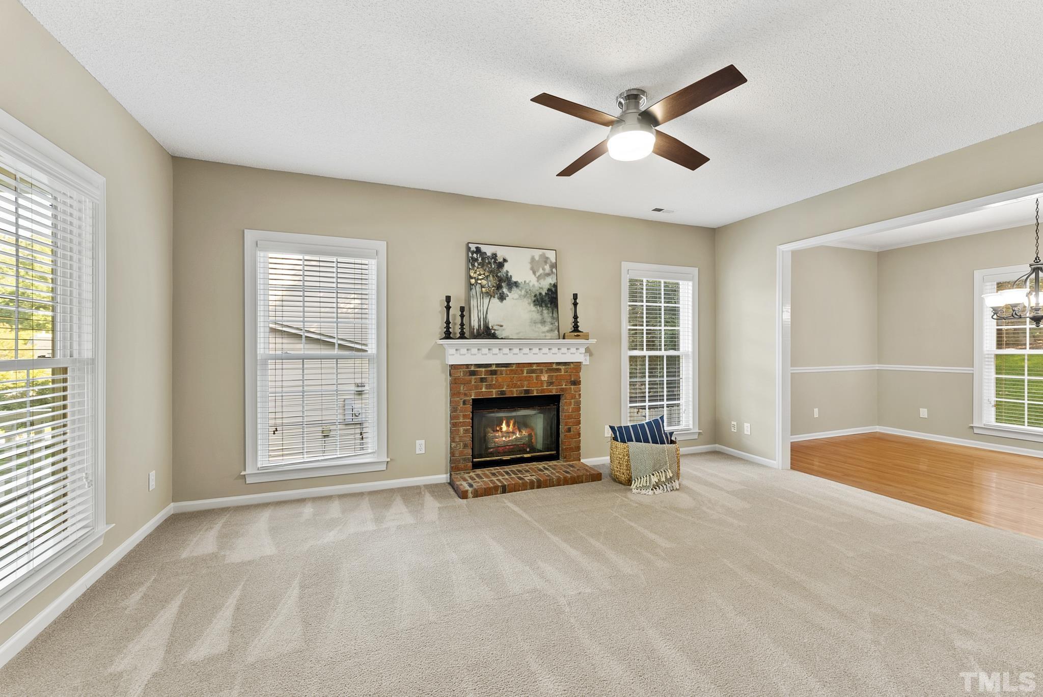 313 Catlin Road Cary, NC 27519 - Photo 5 of 27 an empty room with fireplace fan and windows
