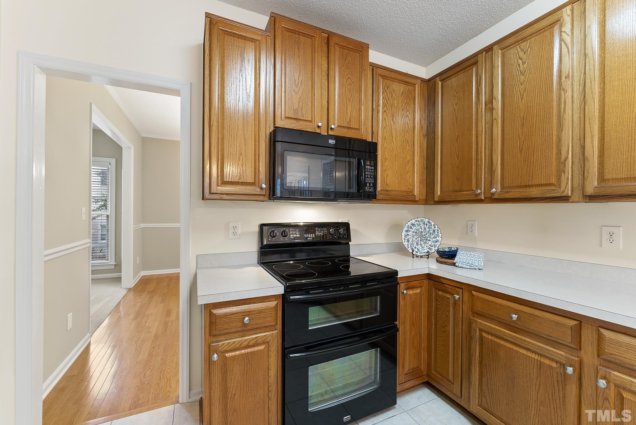 313 Catlin Road Cary, NC 27519 - Photo 9 of 27 a kitchen with granite countertop wooden cabinets and a stove top oven