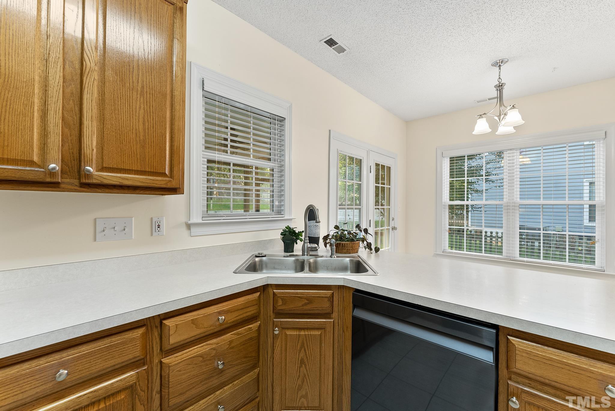313 Catlin Road Cary, NC 27519 - Photo 10 of 27 a kitchen with stainless steel appliances granite countertop a sink a stove and a wooden cabinets
