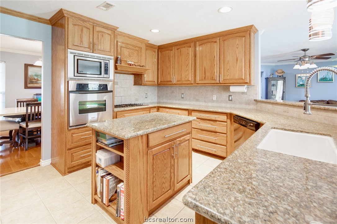 209 Ranchette Court Bryan, TX 77808 - Photo 11 of 37 a kitchen with stainless steel appliances granite countertop a sink stove and cabinets