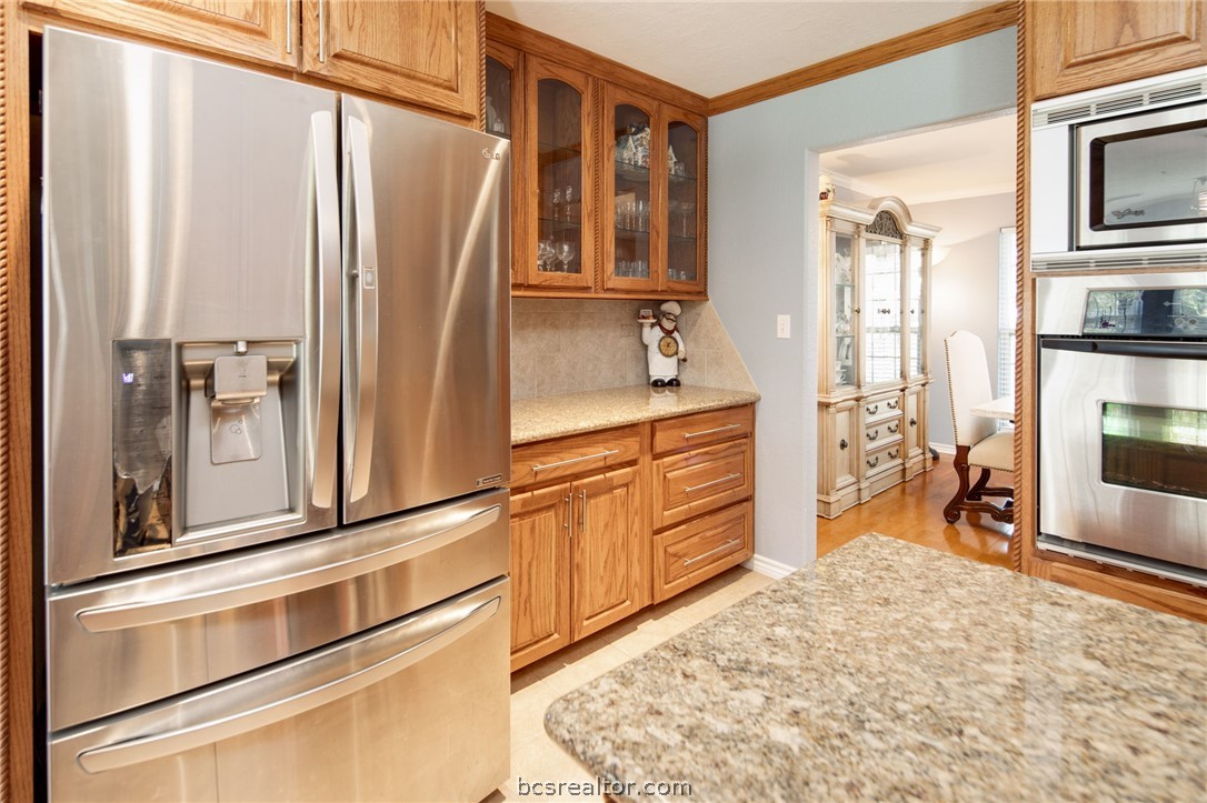 209 Ranchette Court Bryan, TX 77808 - Photo 13 of 37 a kitchen with stainless steel appliances granite countertop a refrigerator and a stove