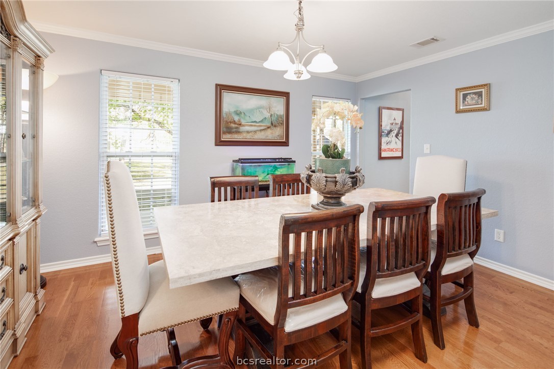 209 Ranchette Court Bryan, TX 77808 - Photo 15 of 37 a view of a dining room with furniture wooden floor and a chandelier